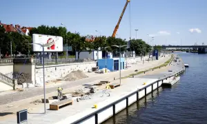 Trwa rewitalizacja Bulwaru Piastowskiego w Szczecinie. Widoczny plac budowy, dźwig i pracownicy nad Odrą.